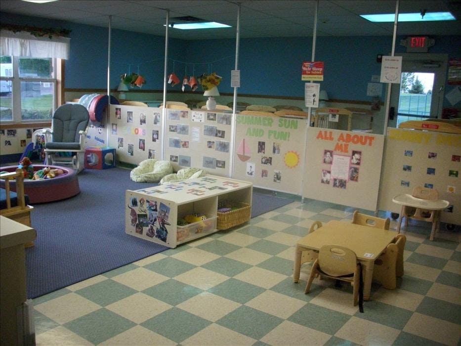 A childcare center with play areas and cribs divided by partitions