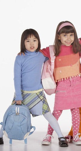 Two children with backpacks standing together