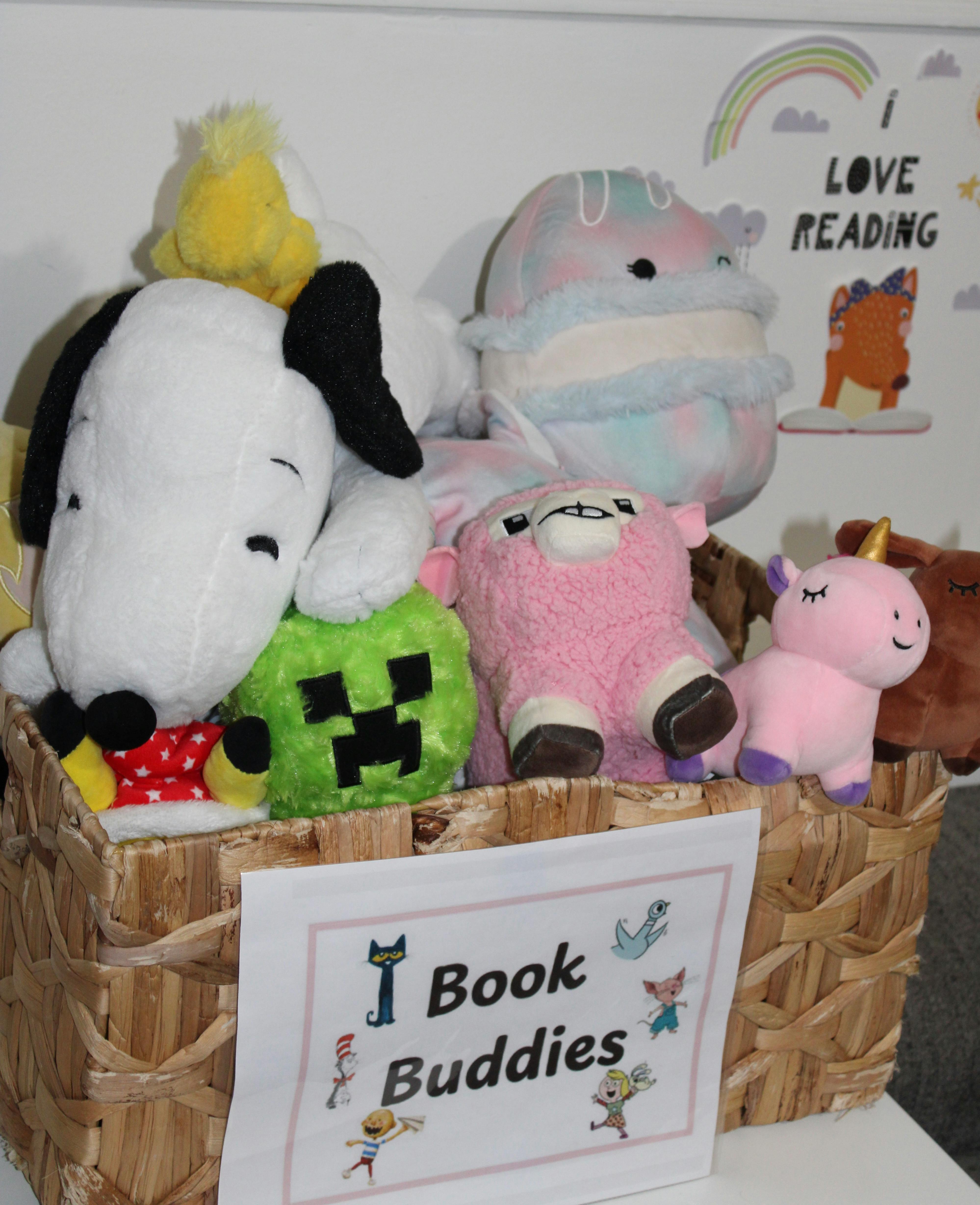 A woven basket filled with various stuffed animals, with a sign that reads "Book Buddies"