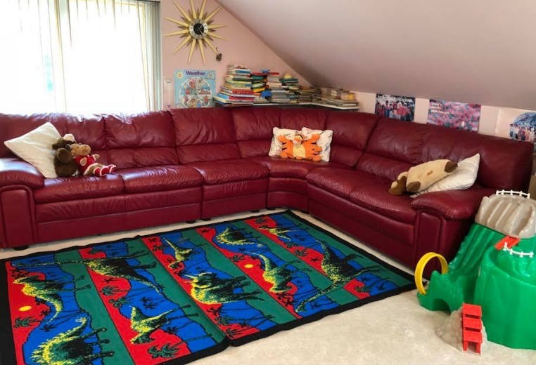 Red sectional sofa with a colorful rug in front of it