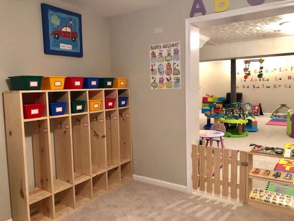 Classroom with cubbies and colorful bins, doorway to play area