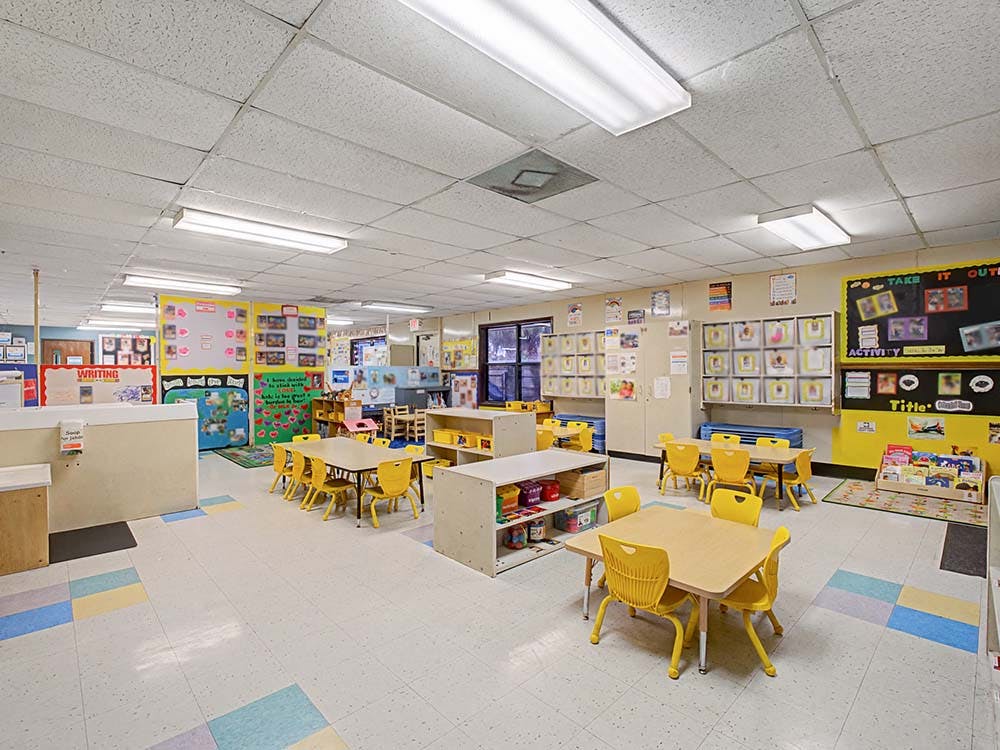 Empty classroom with small tables and chairs