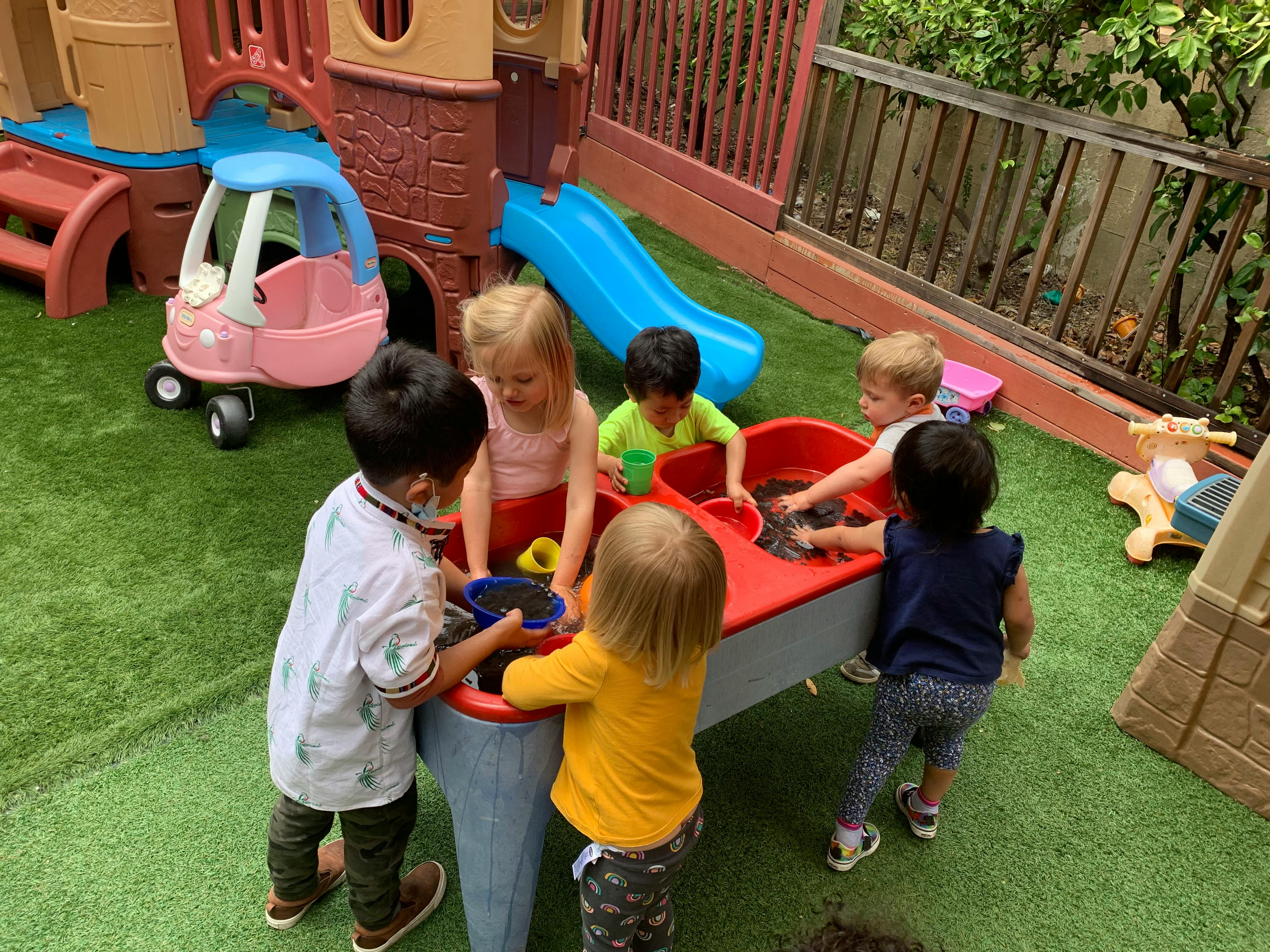 Children playing at a water table outdoors