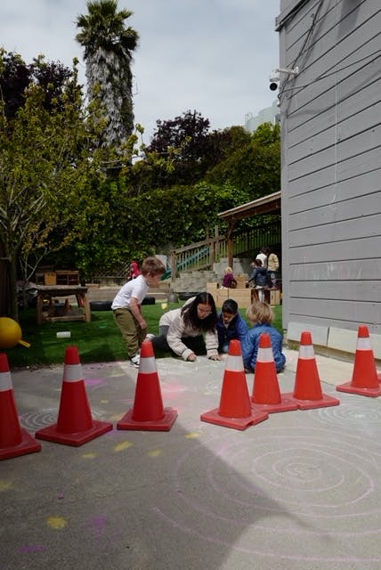 Adult and children playing with cones outdoors