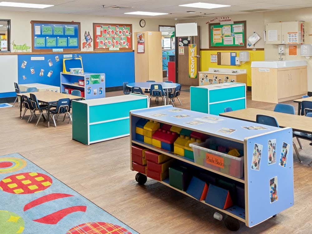 Empty classroom with colorful furniture, tables, and learning materials