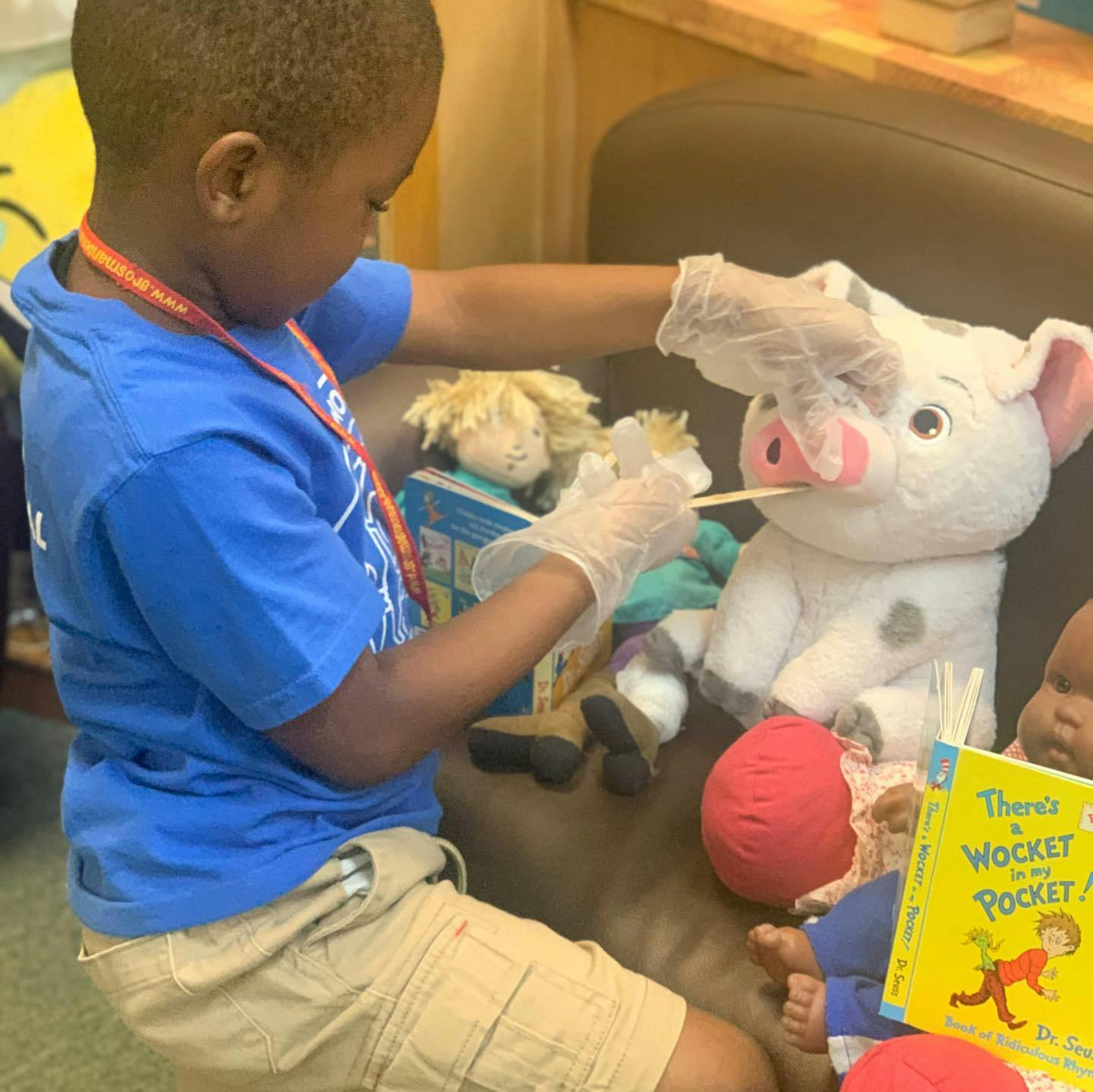 Child wearing gloves playing with stuffed animals