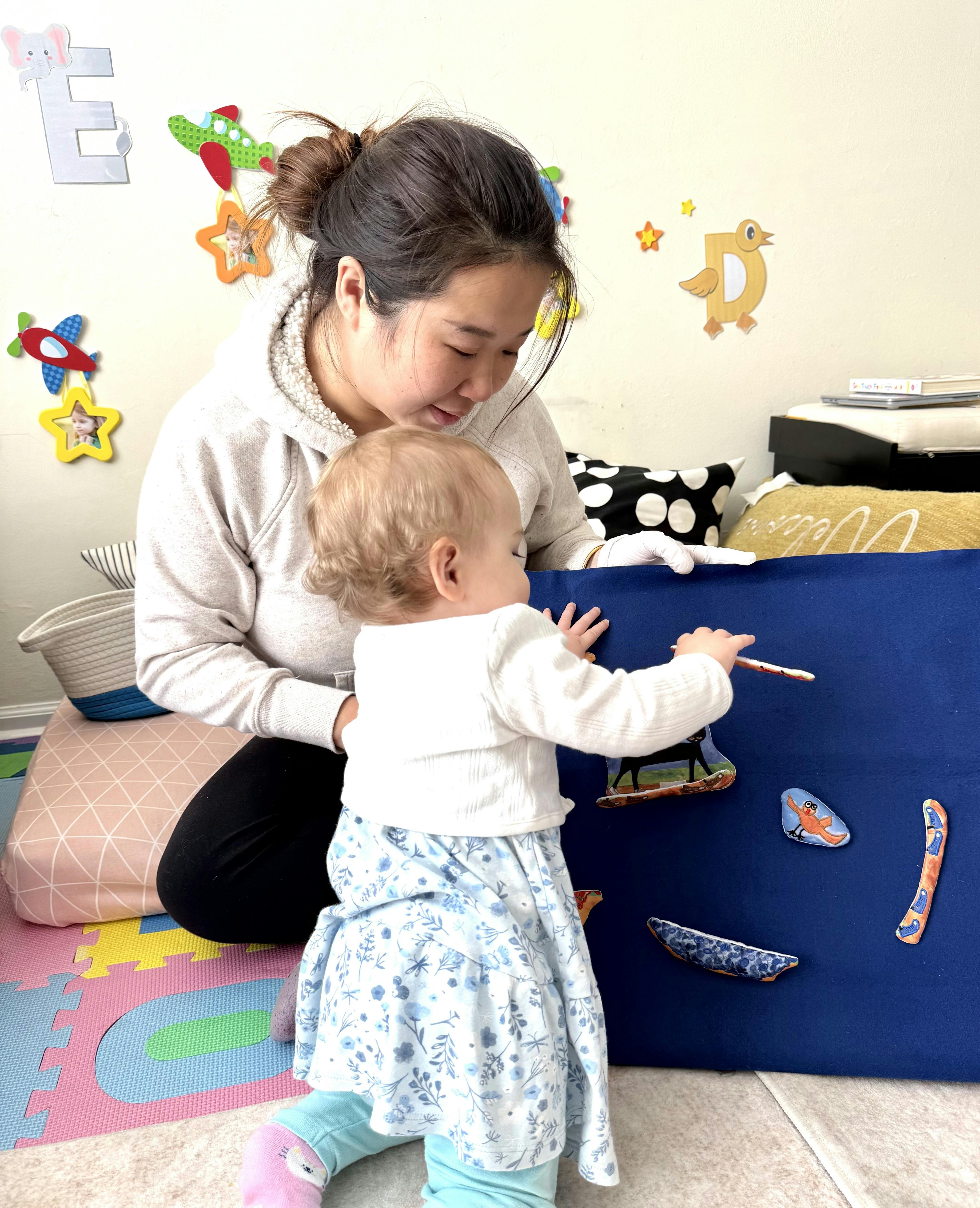 Adult and child playing with a felt board in a playroom