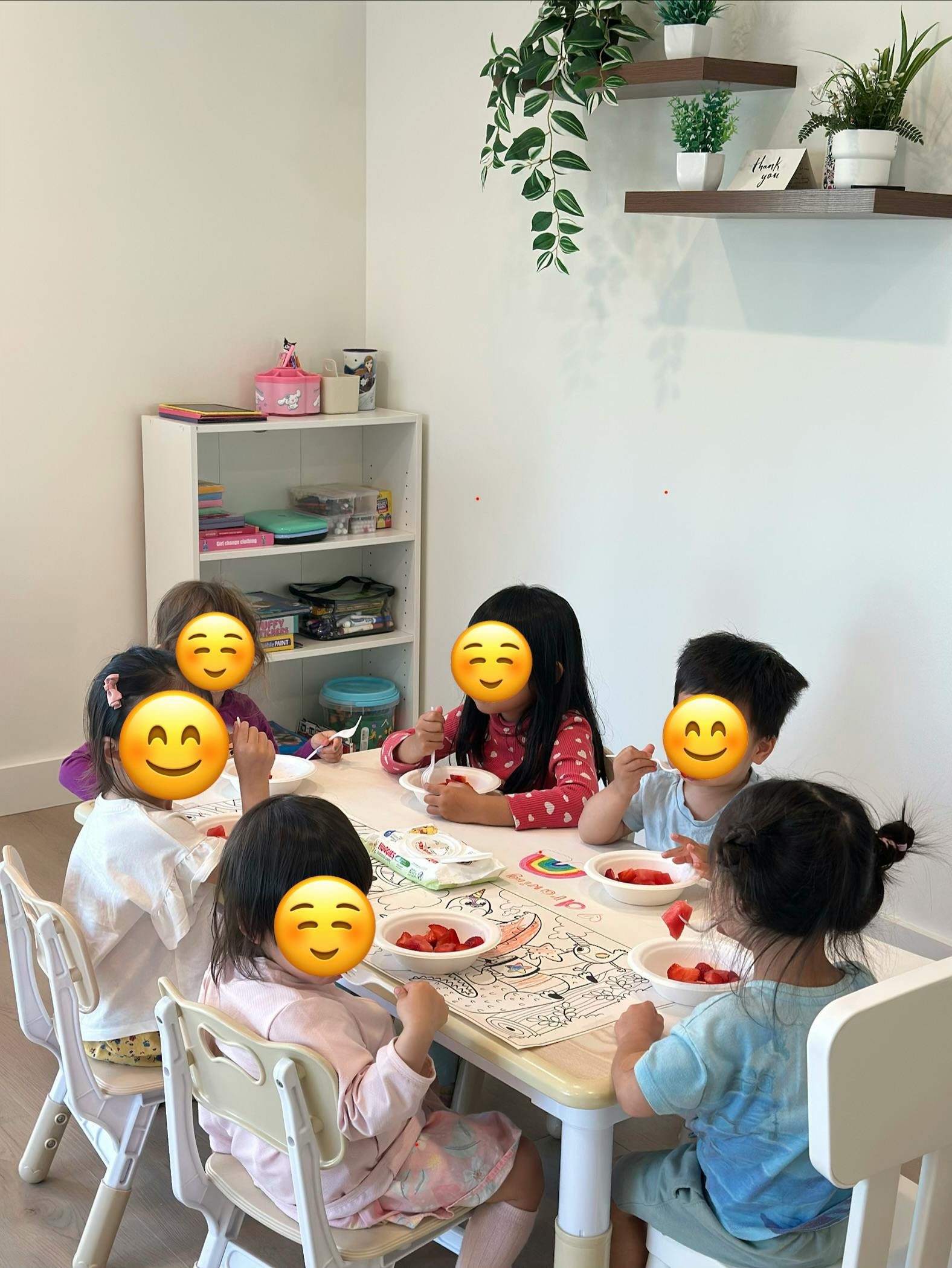 Group of children eating fruit at a table