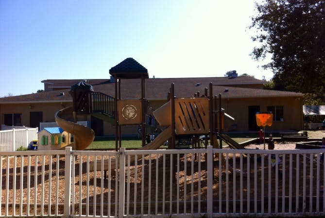Playground with slides and climbing structures in front of a building