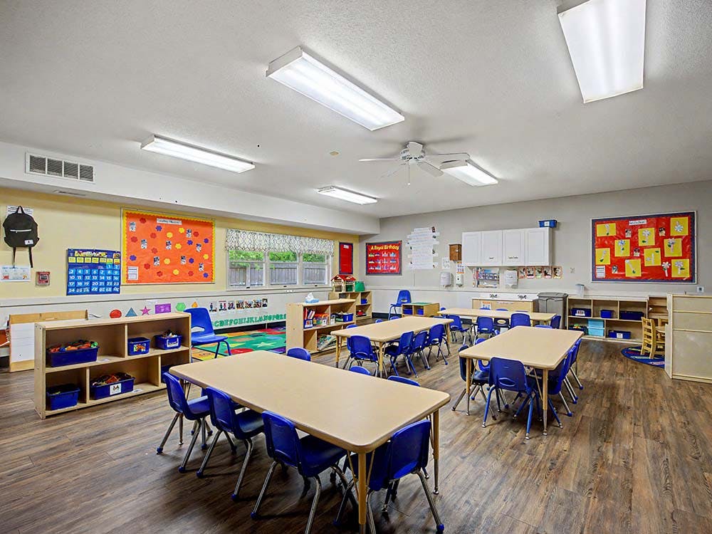 Classroom with tables, blue chairs, and colorful decorations