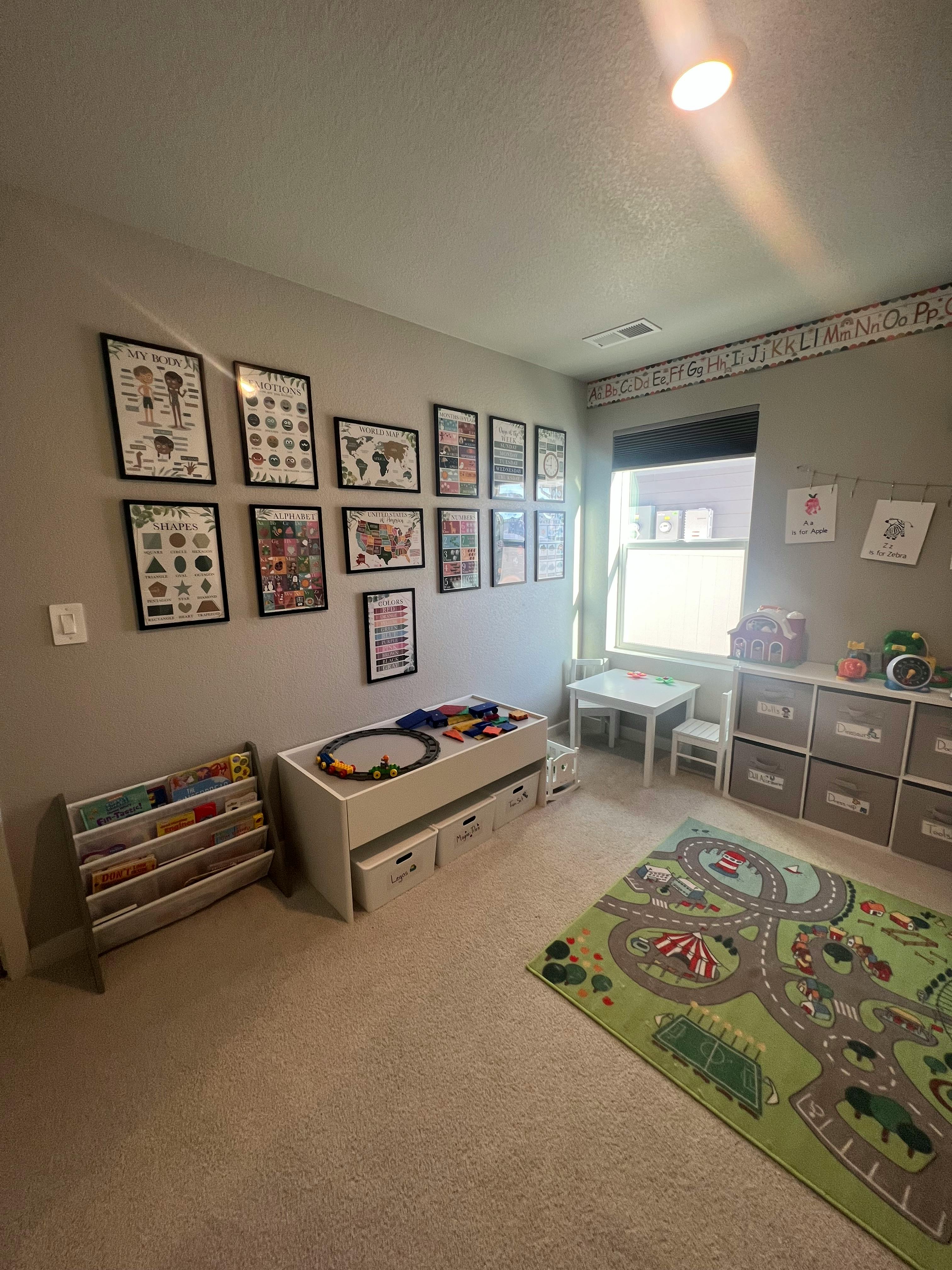 Playroom with a toy table, storage, and a road map rug