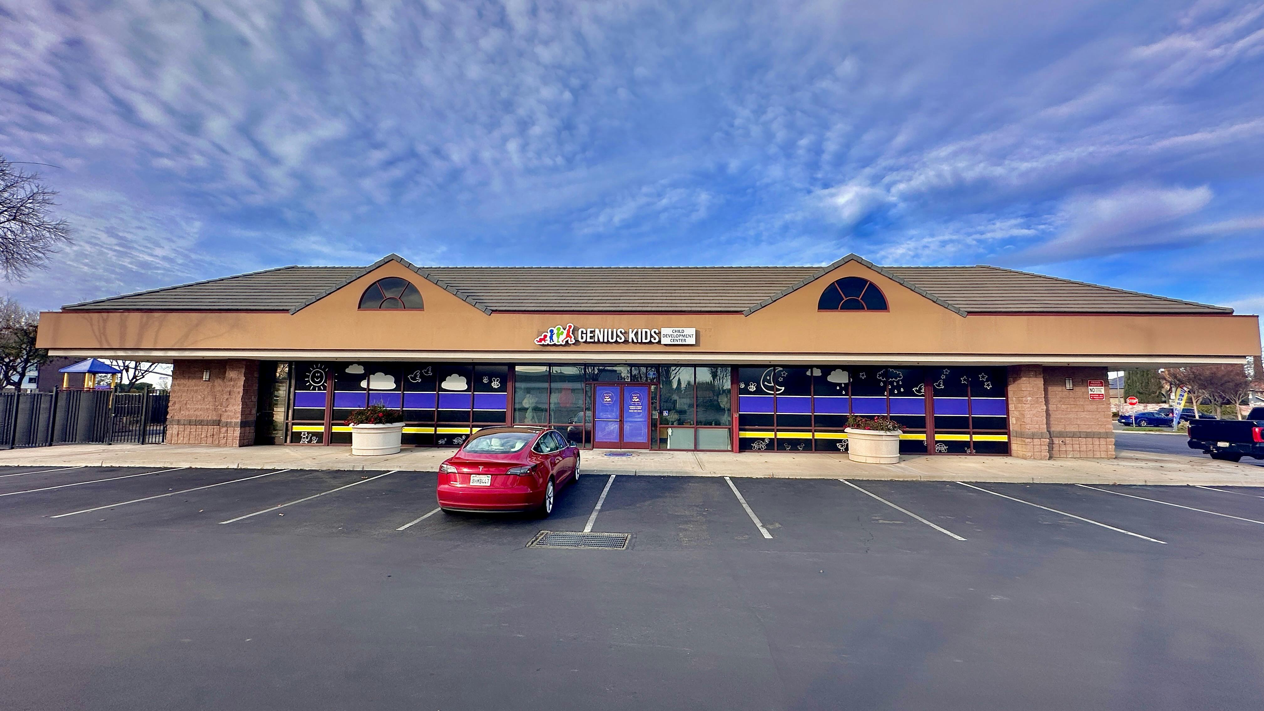 Building with a red car in a parking lot