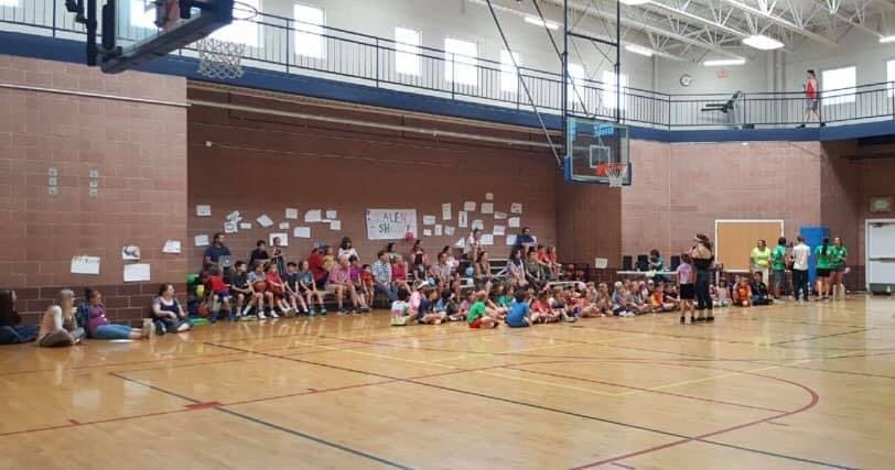 People sitting on a gymnasium floor