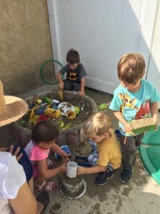 Children playing with toys in a sand and water table