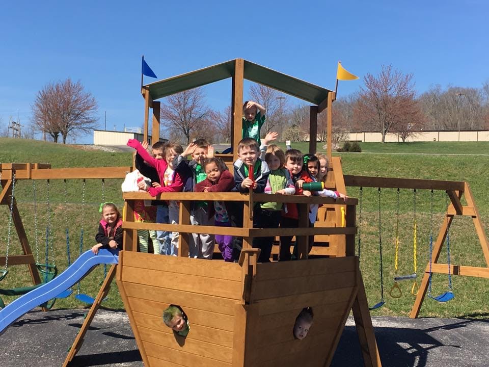 Group of children on a wooden playground structure