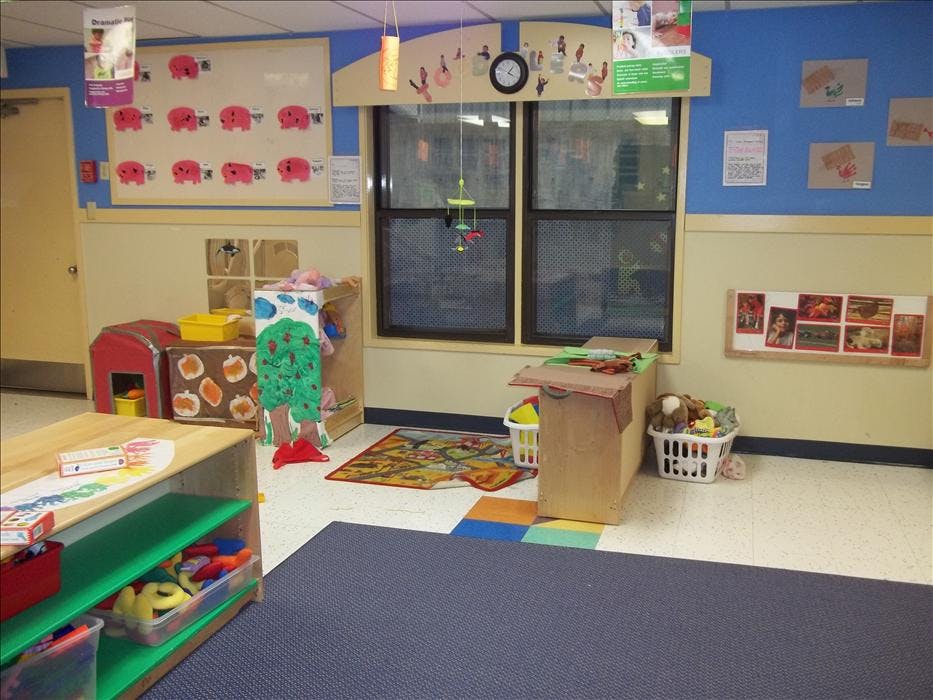 Child's classroom with blue and cream walls, toys, and large windows
