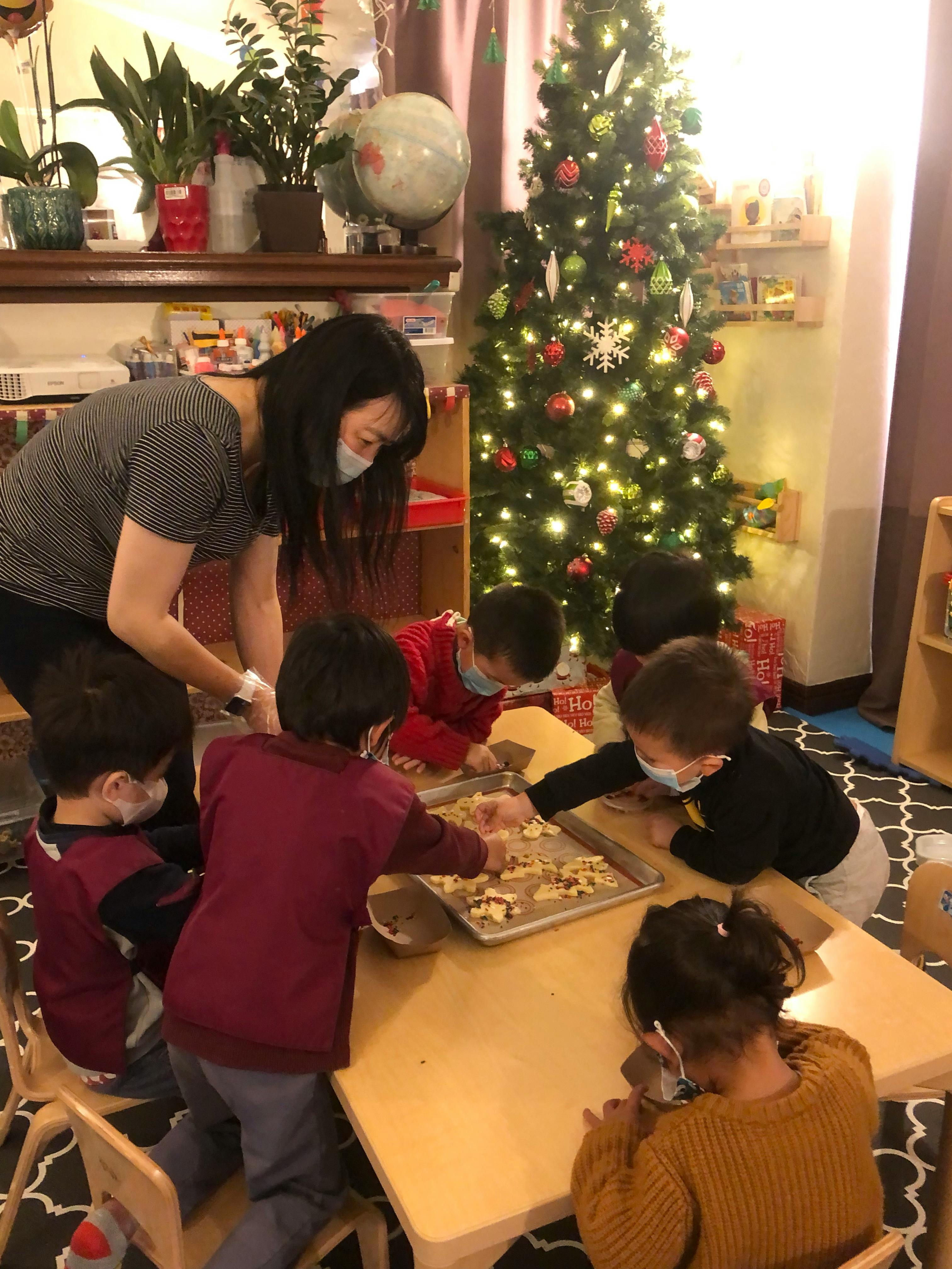 Person and children making cookies in a classroom