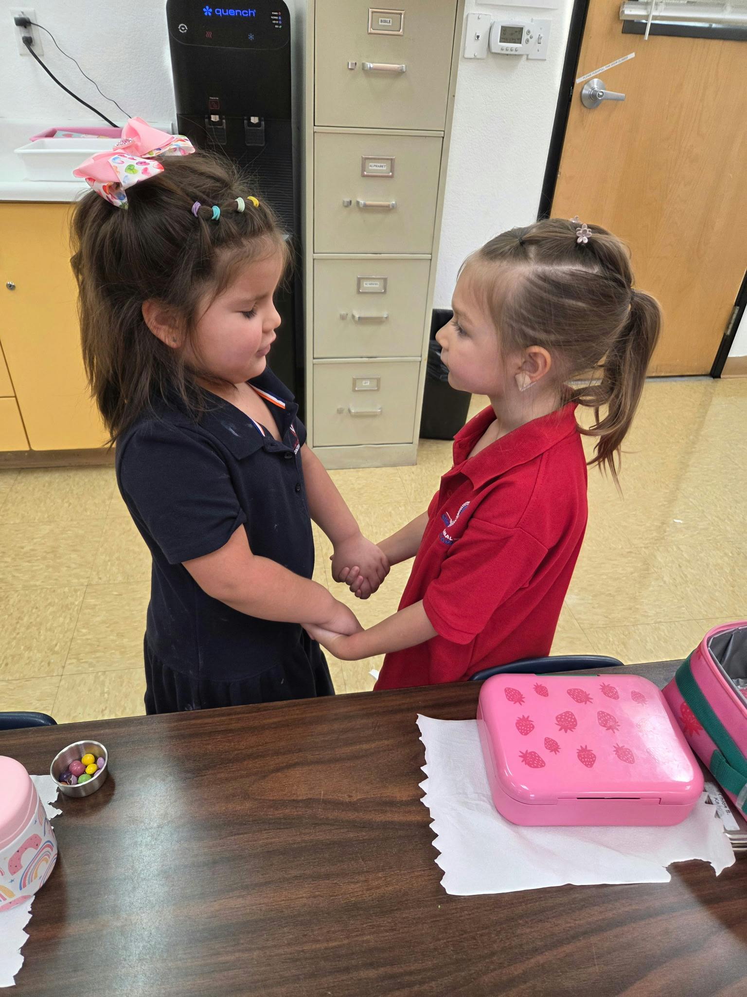 Two children holding hands across a table