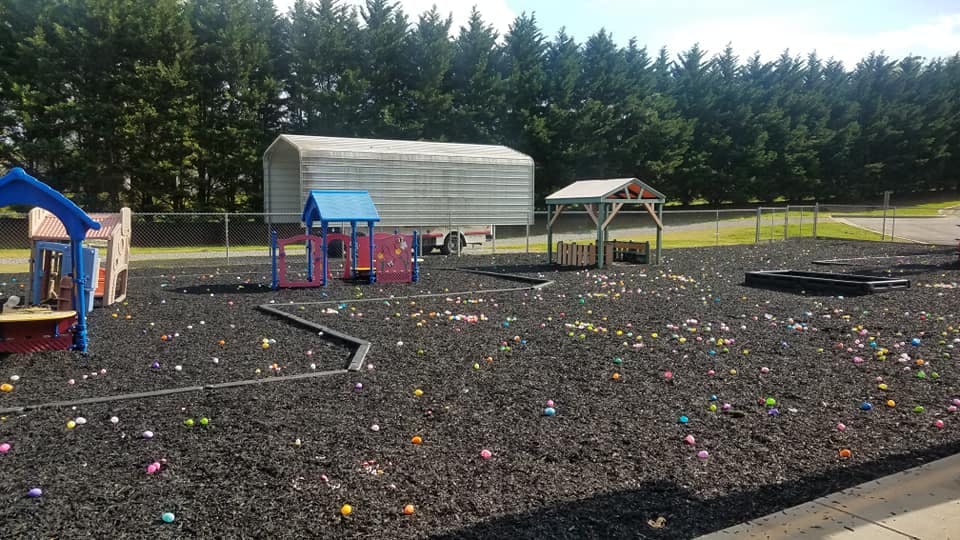 Playground with play structures and small colorful objects scattered on the ground