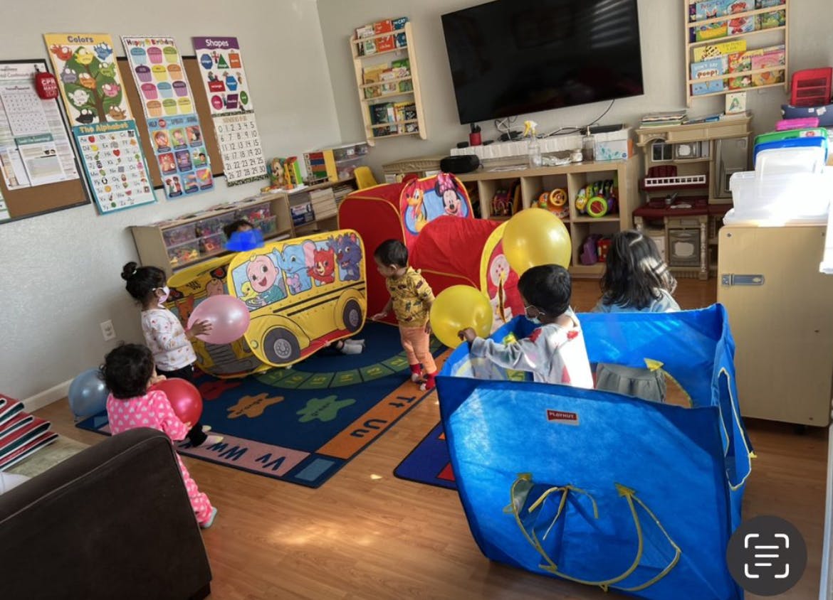 Children playing with balloons and toys in a room