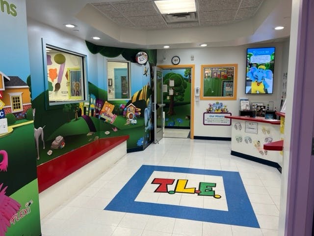 Playroom with colorful wall murals and a reception desk