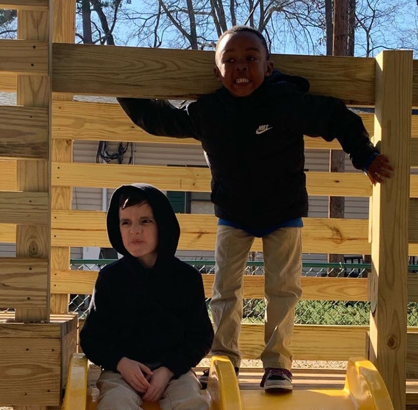 Two children on a wooden play structure