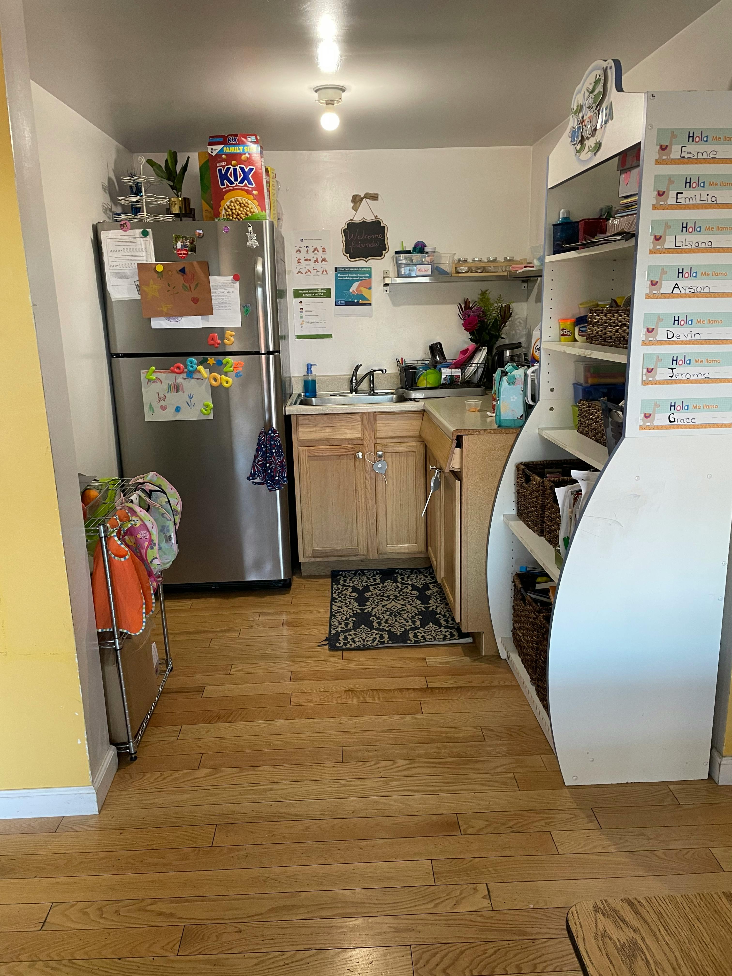 Small kitchen with a refrigerator, sink, and shelving