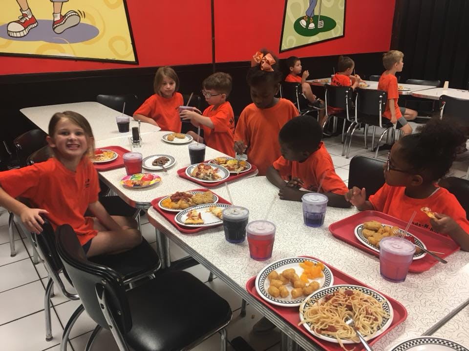 Children eating meals at tables