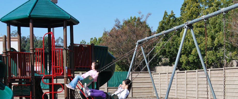 Two children on swings at a playground