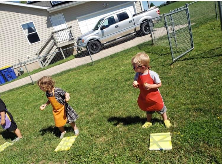 Children in aprons playing on grass