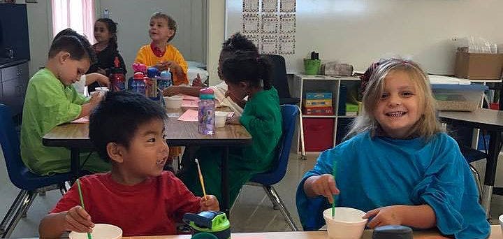 Children sitting at tables in a classroom