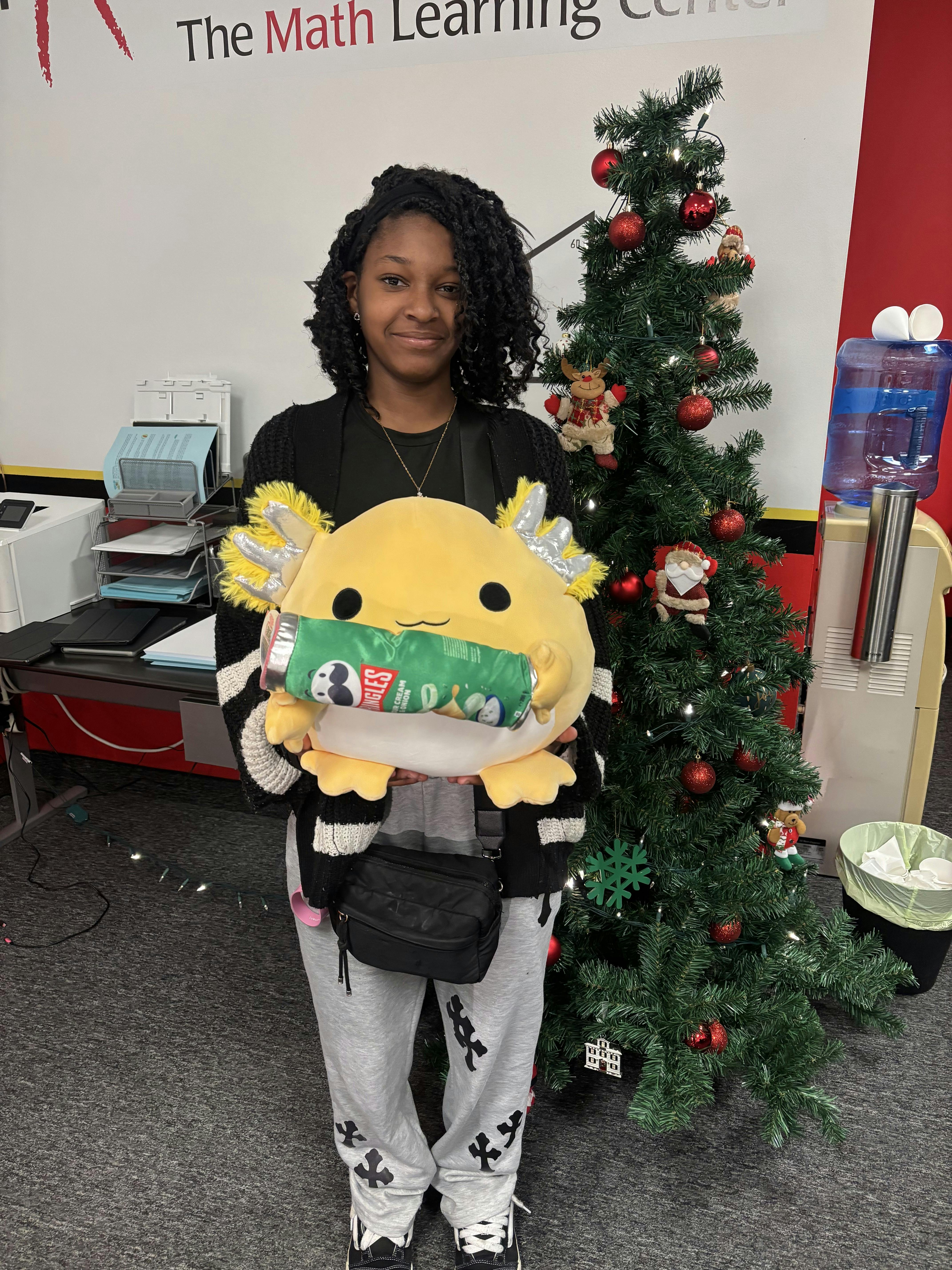 Person holding a large yellow stuffed animal with a snack