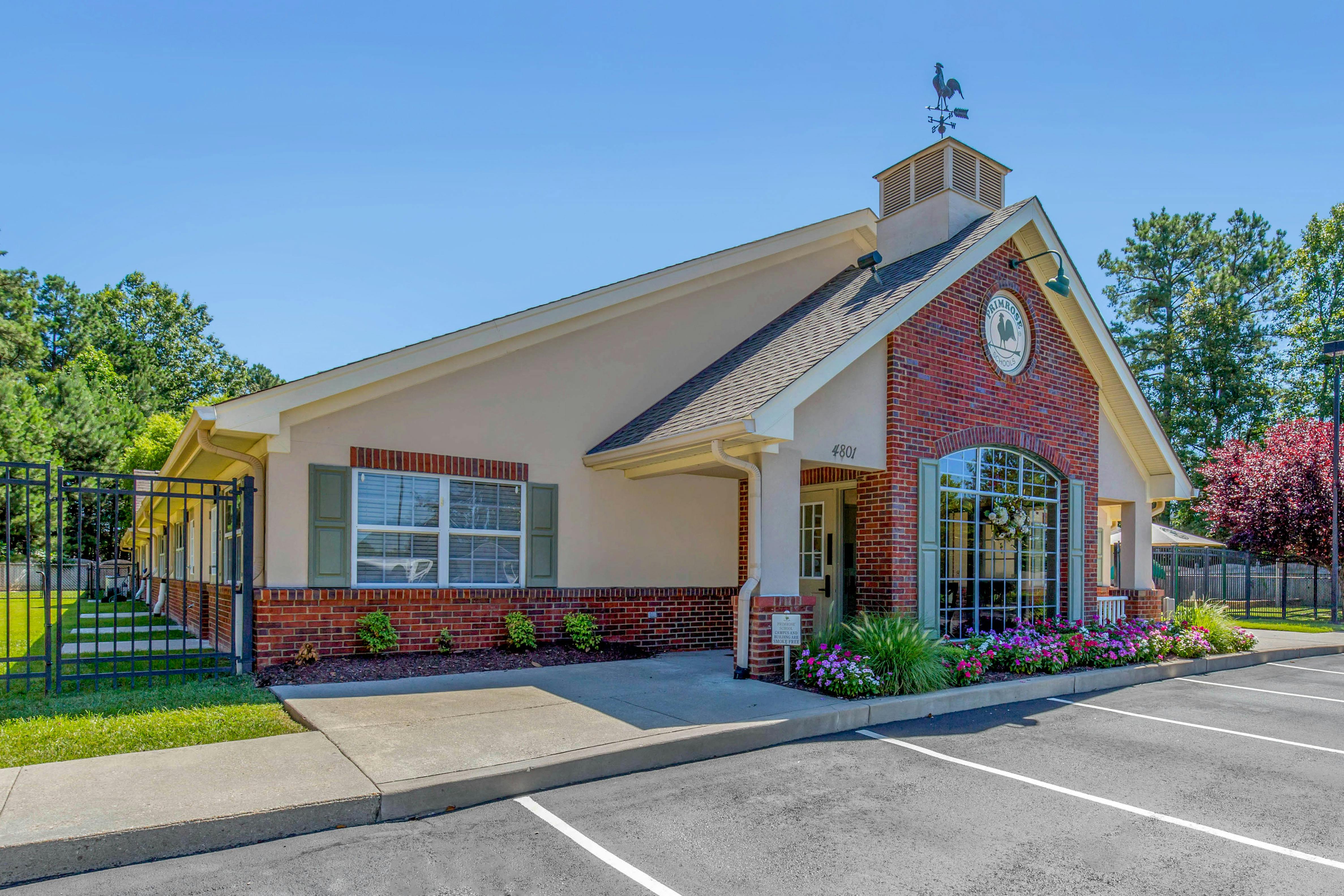 Exterior view of a Primrose Schools building, a brick and stucco building with a weathervane
