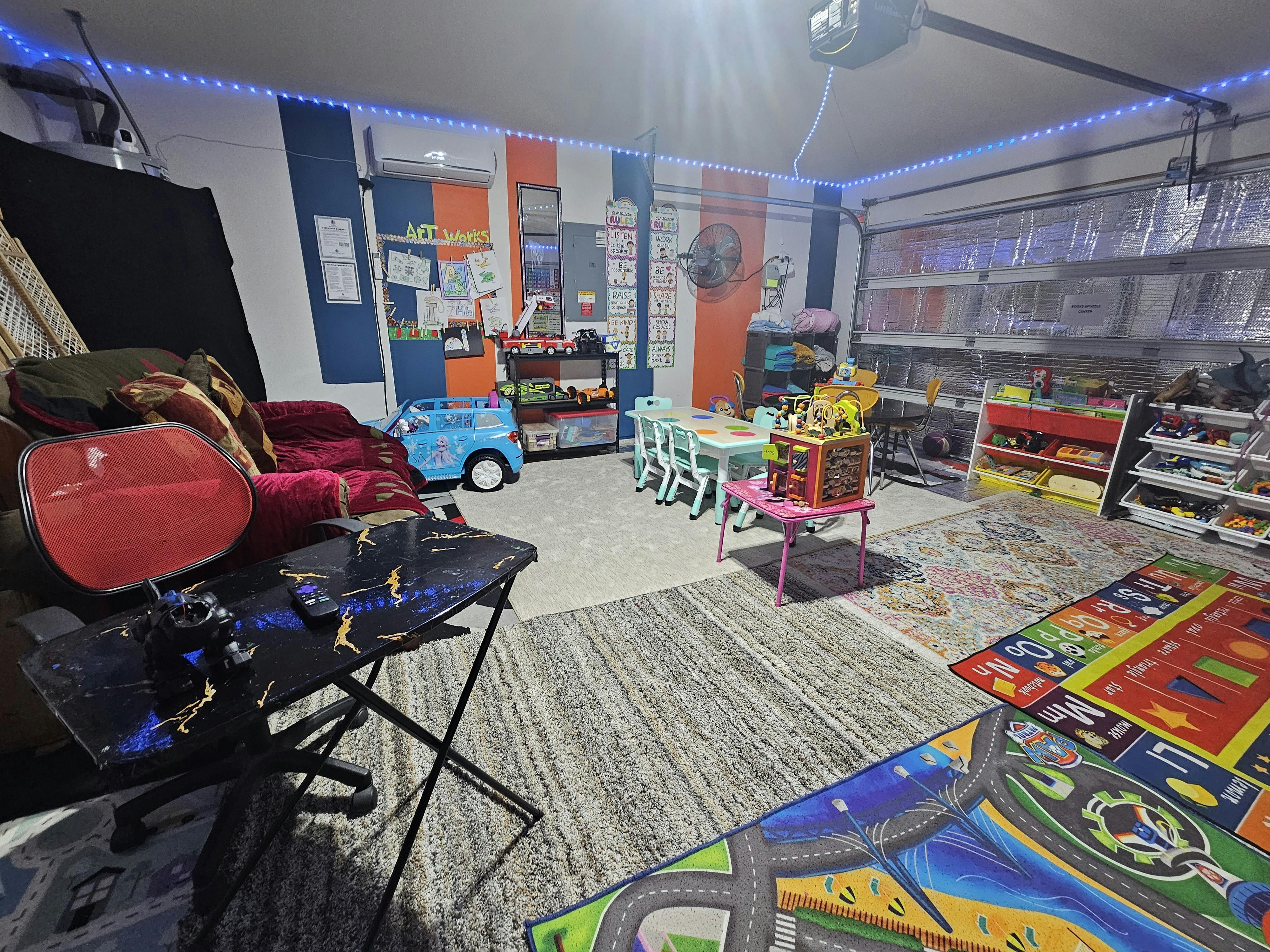 Playroom with small tables and chairs, toy shelves, and colorful rugs