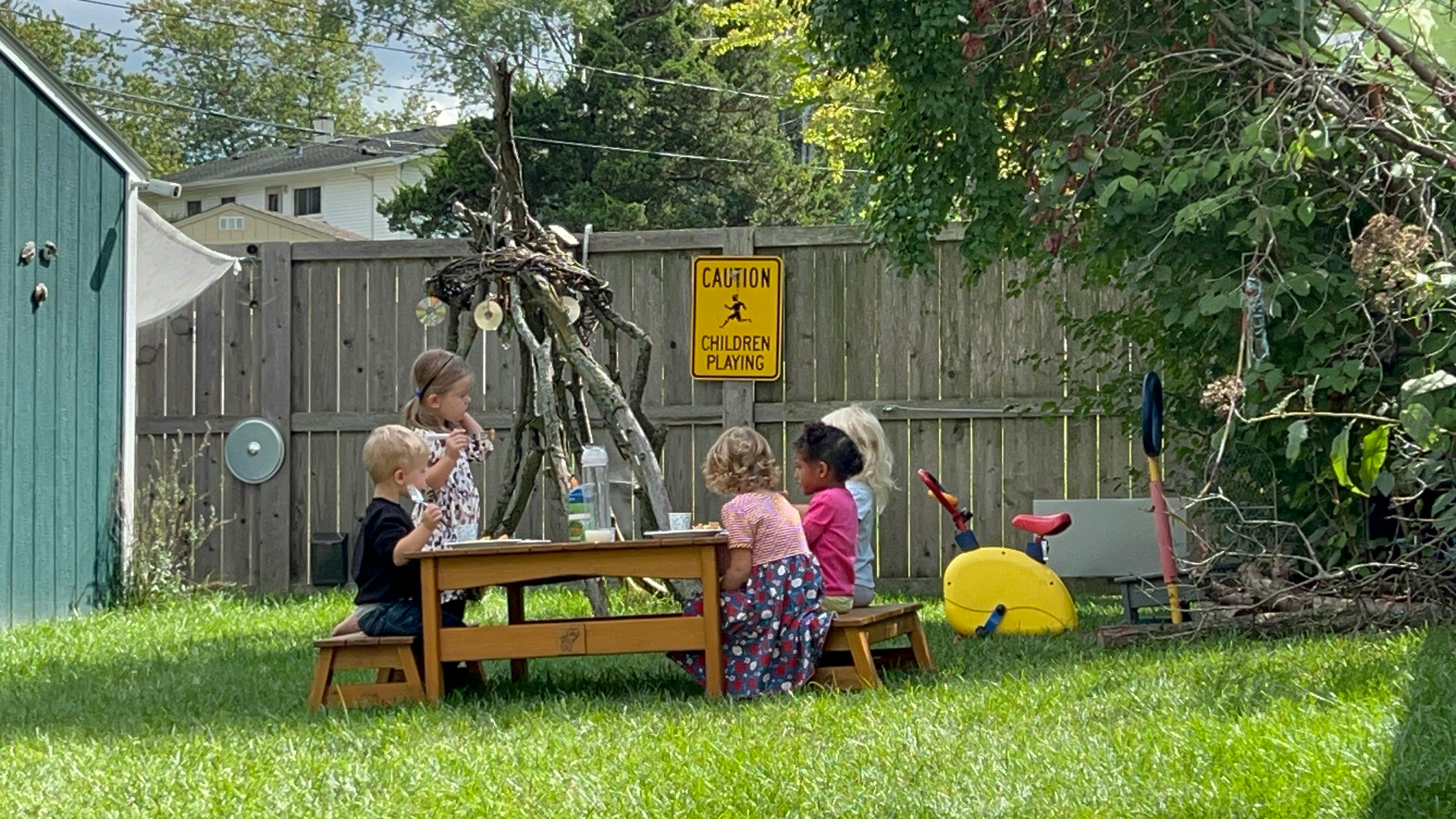 Children sitting at a picnic table outdoors