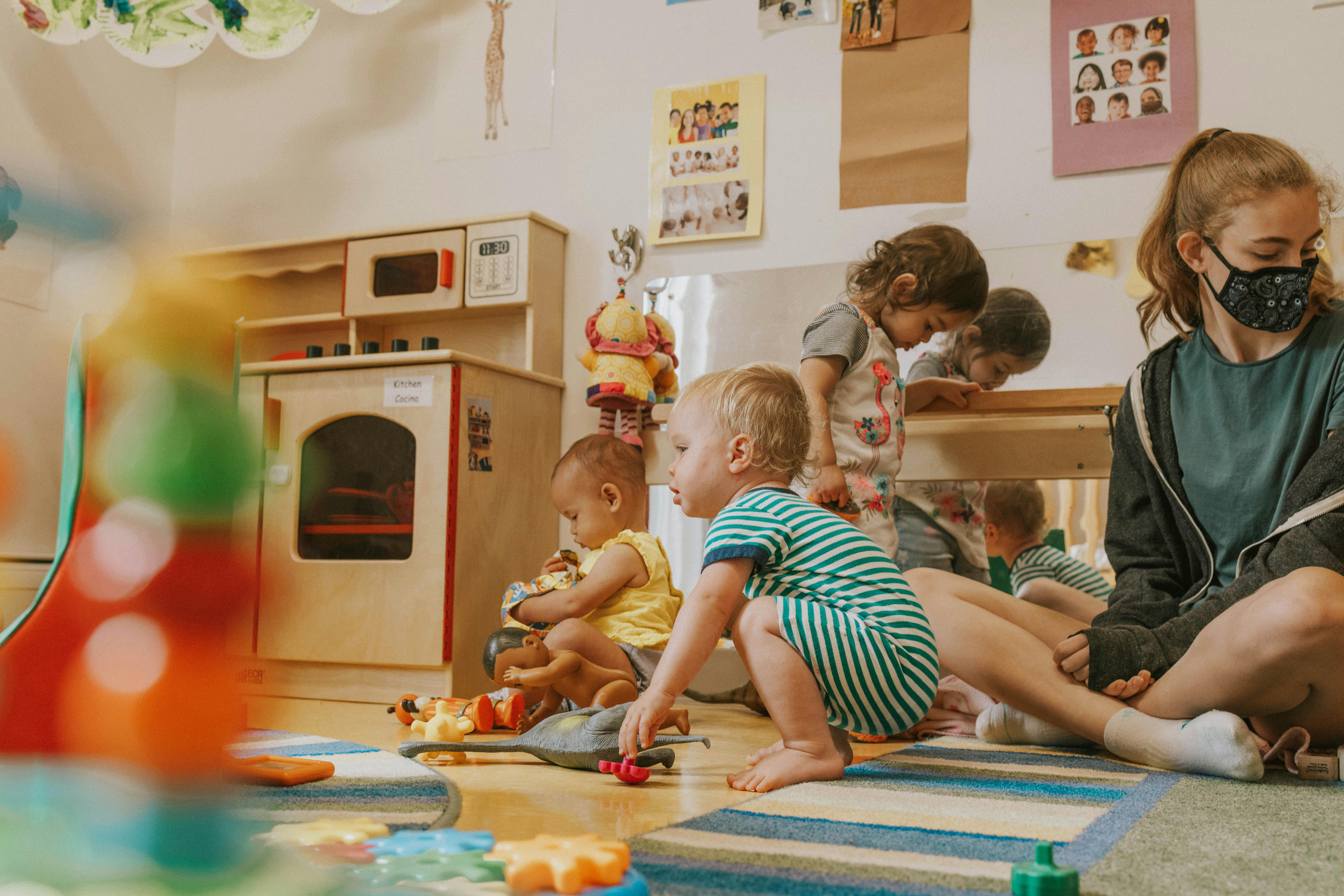 Adult and children playing on floor in classroom