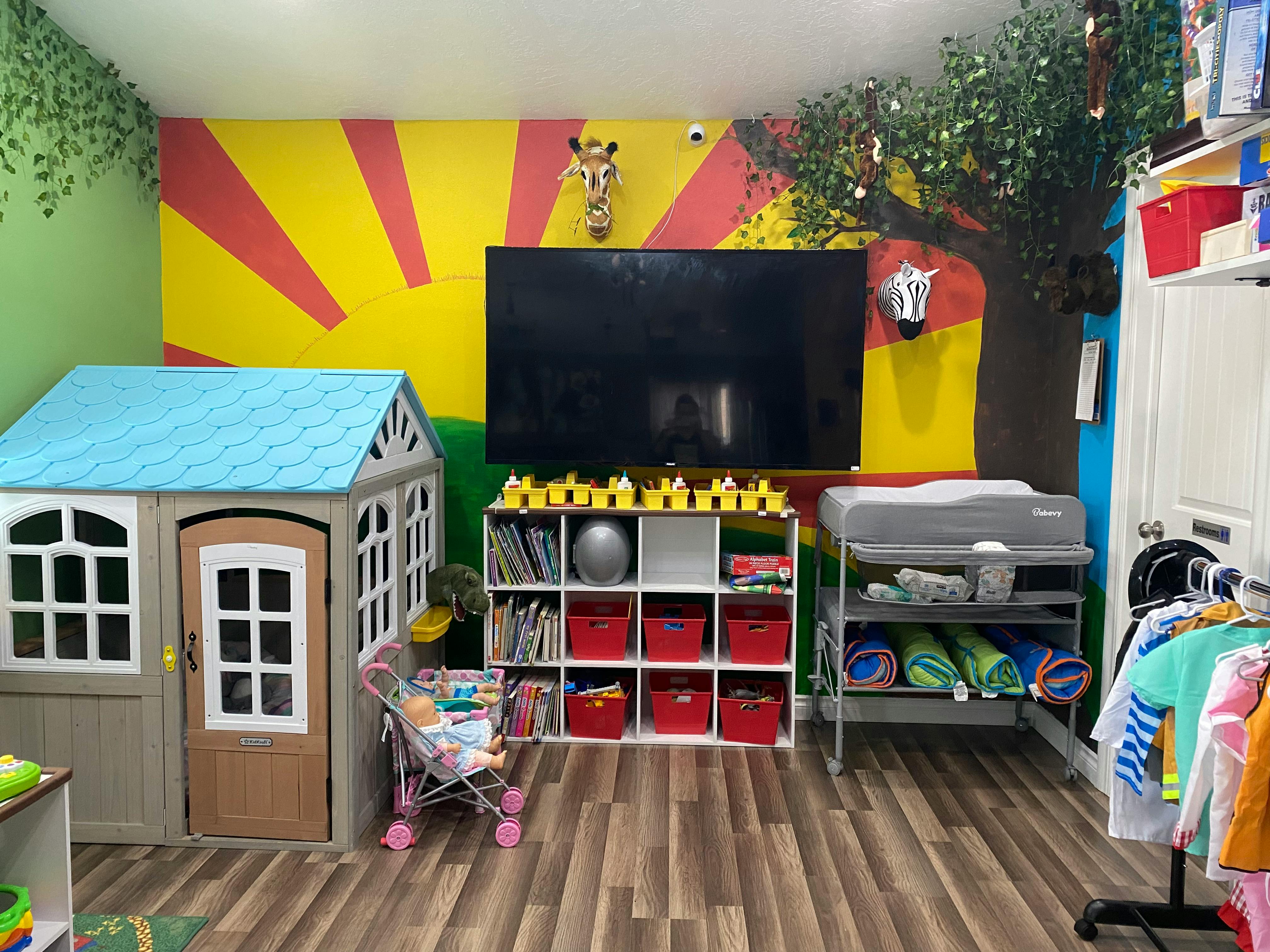 Playroom with a playhouse, television, and storage shelves