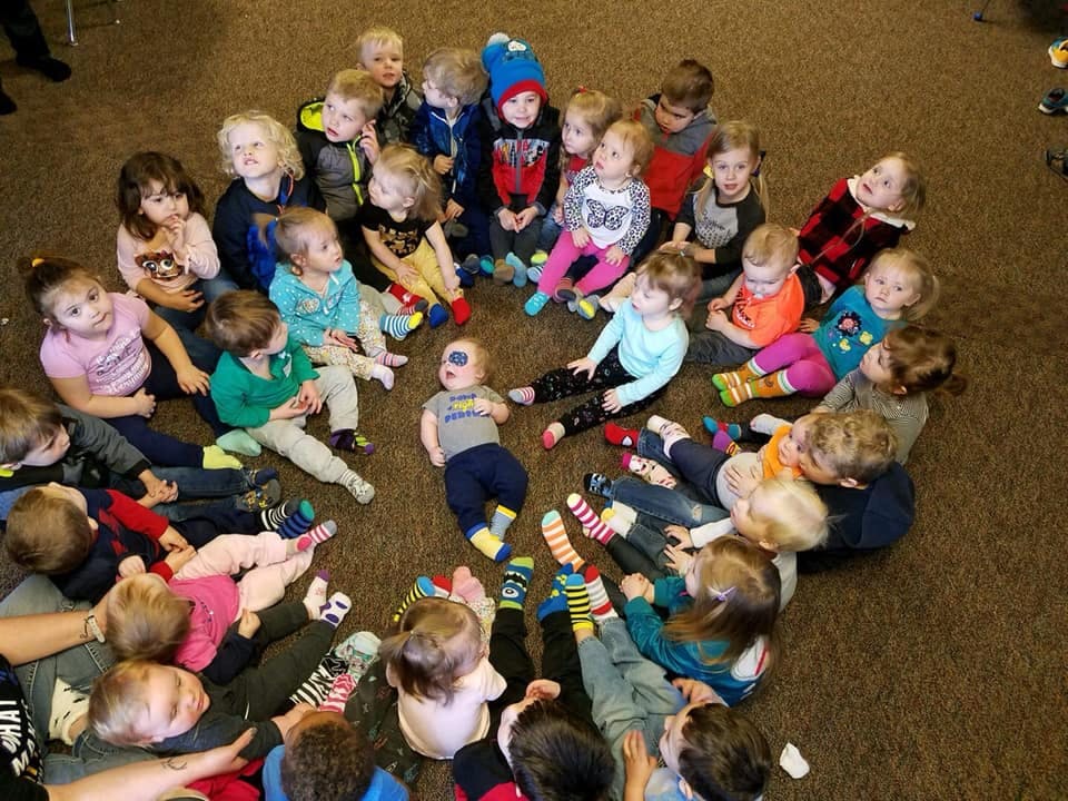 Many children sitting in a circle on the floor