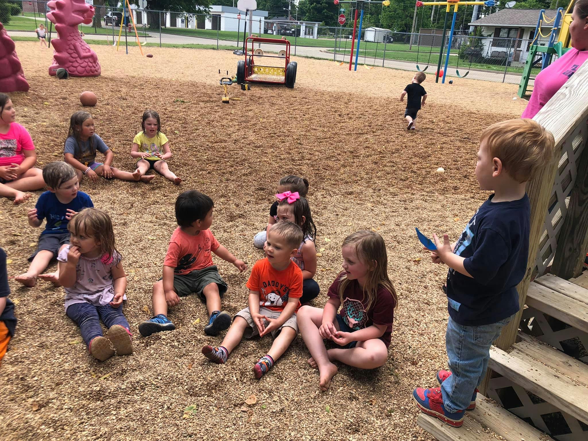 Children sitting on the ground in a playground