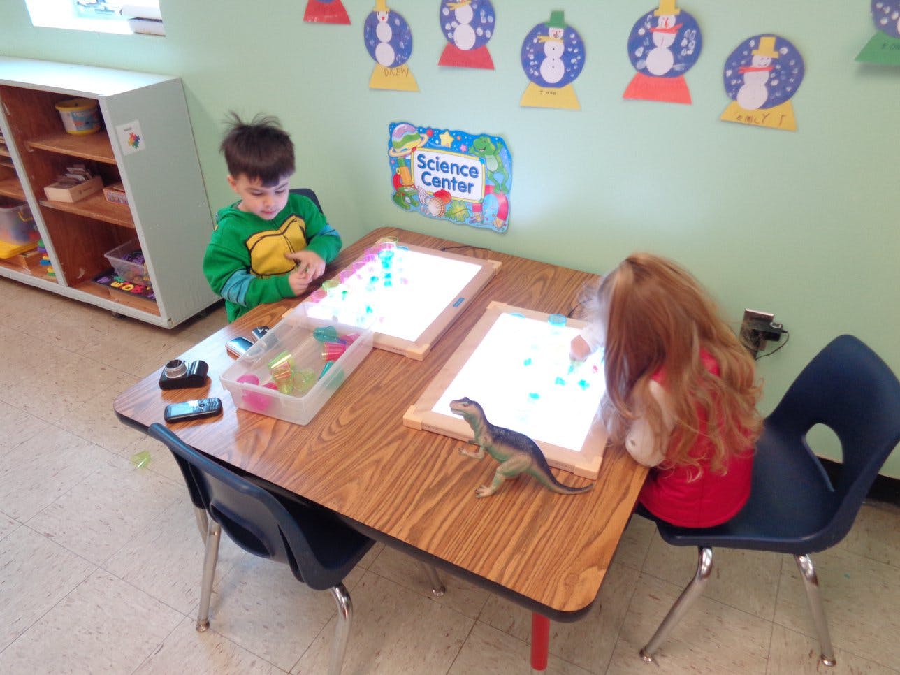 Two children at a table with light boards