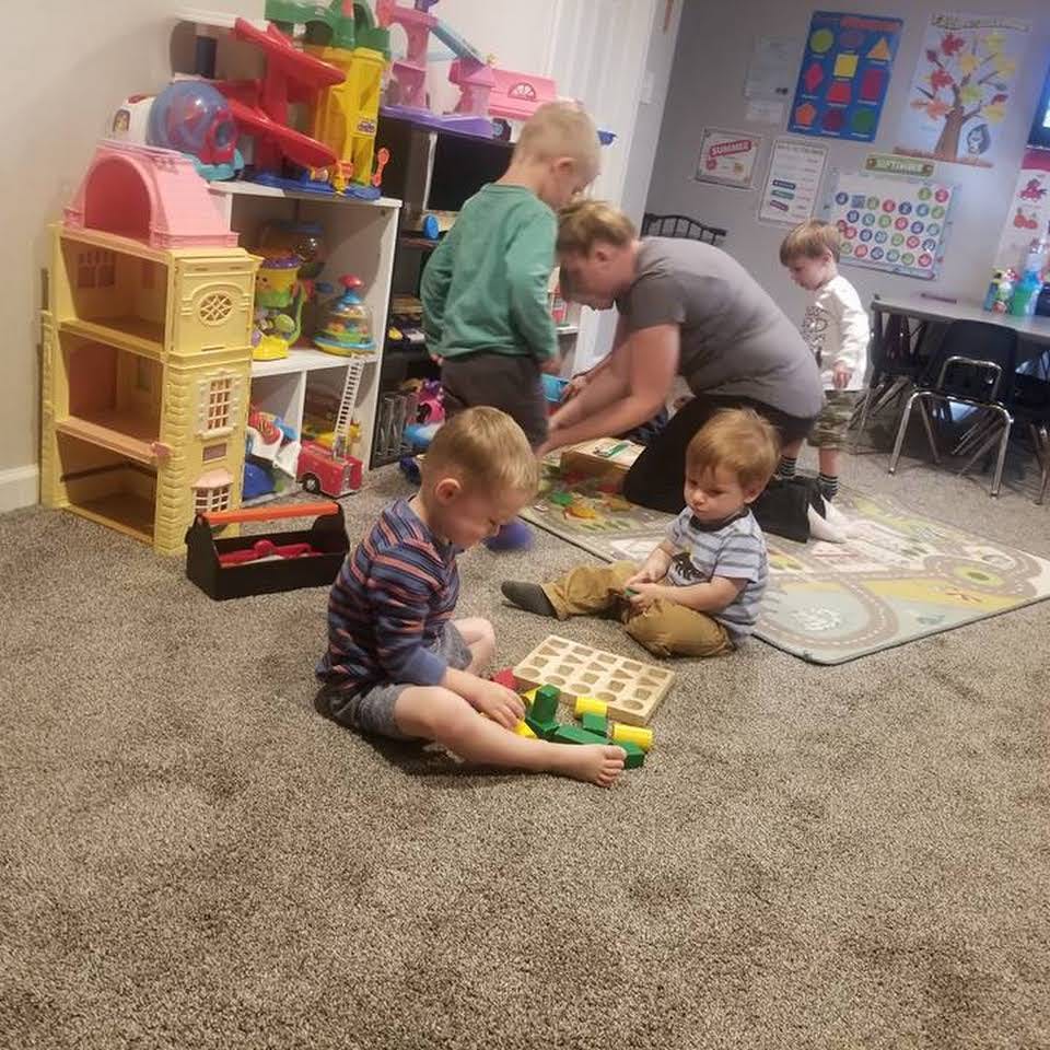 Adult and children playing with toys in a room