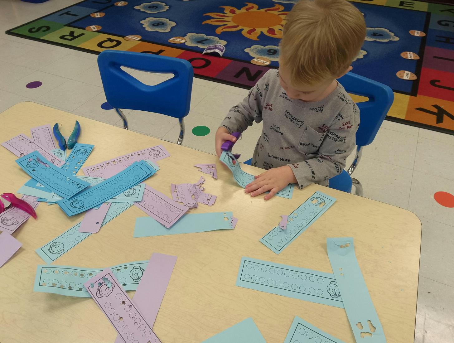 Child cutting paper strips at a table