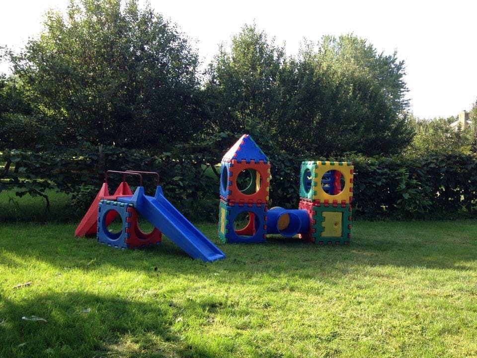 Playground equipment with slide and climbing structures on grass