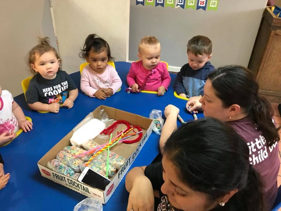 Adults and children sitting around a table with craft supplies