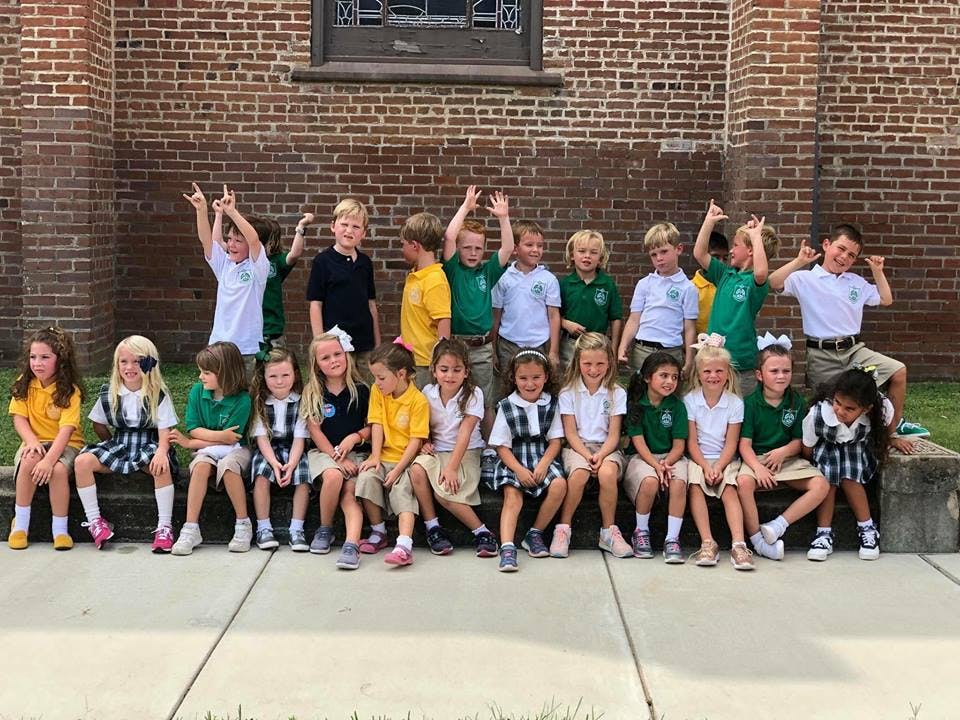 Group of children in school uniforms posing outdoors