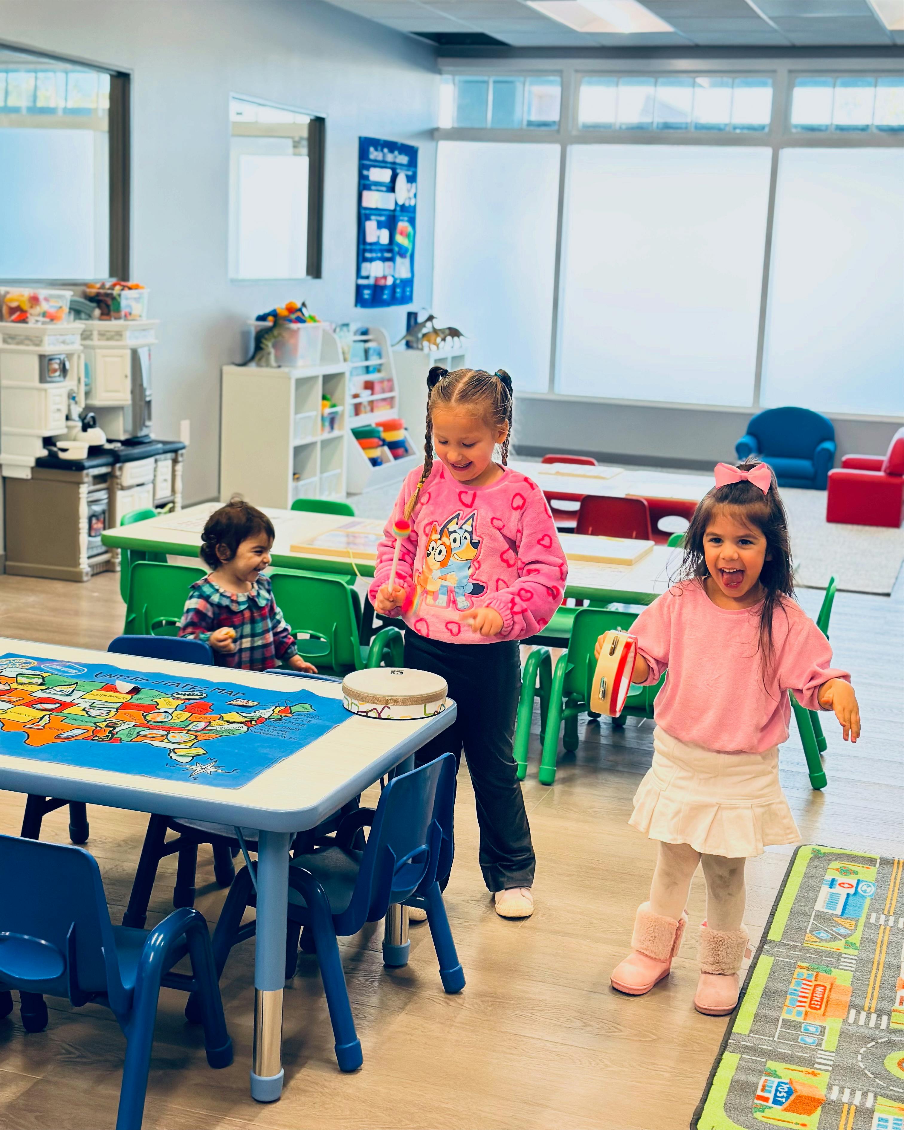Three children playing in a classroom