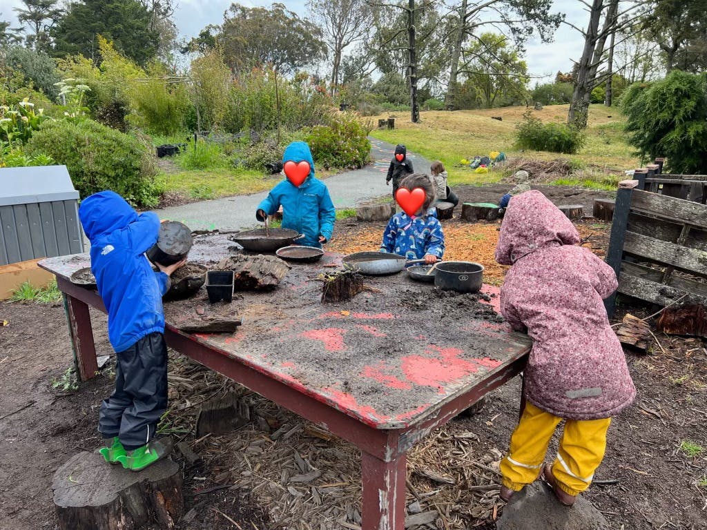 Children playing at a mud kitchen outdoors