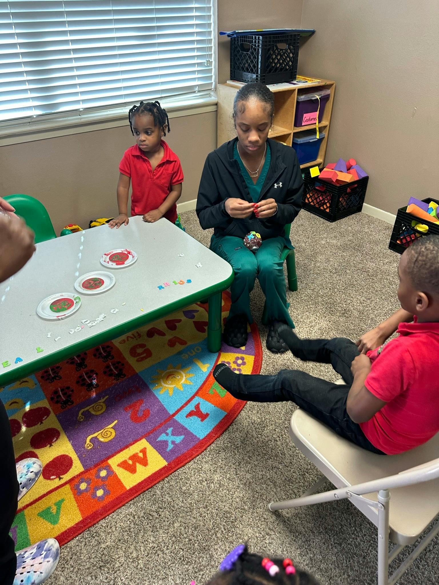 Adult and children sitting around a small table in a room