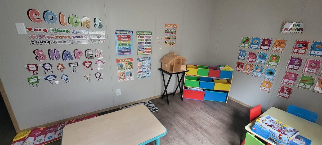Classroom with educational posters on walls and colorful storage bins