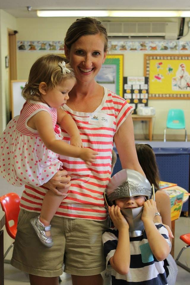 Person holding a child, another child wearing a helmet